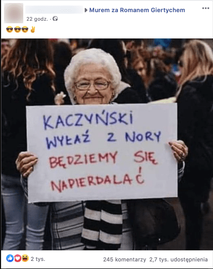 Starsza kobieta w czasie protestu trzyma transparent z napisem Kaczyński wyłaź z nory będziemy się napierdalać
