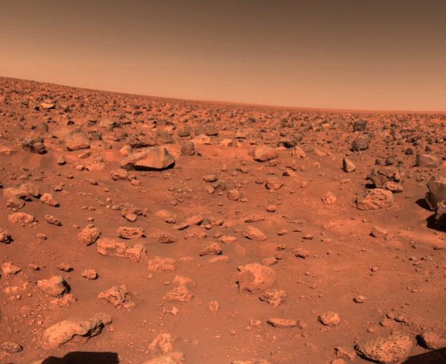 Zdjęcie przedstawiające powierzchnię Marsa. Zarówno podłoże, kamienie jak i niebo ma czerwono-pomarańczowe barwy.