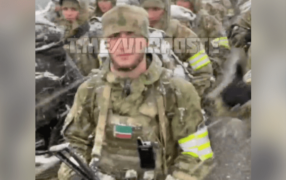 Klatka z filmu, która przedstawia jednego z żołnierzy. Na jego klatce piersiowej znajduje się czeczeńska flaga.