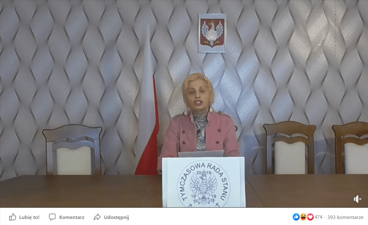 Zrzut ekranu z filmu zamieszczonego na Facebooku, na którym widać samozwańczą prezydent, zasiadająca przy stole i odczytującą swoje przemówienie z kartki. Na film zareagowało ponad 450 osób, a poniżej pojawiło się ponad 390 komentarzy.