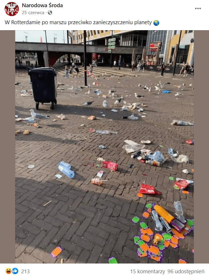 Zrzut ekranu wpisu na Facebooku, w którym przedstawiono zdjęcie mocno zanieczyszczonej ulicy. Na kostce brukowej leży wiele plastikowych butelek i innych plastikowych elementów, a także kontener na odpady, który stoi na środku publicznej drogi.