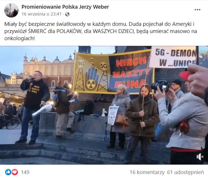 Zrzut ekranu wpisu z nagraniem, które zamieszczono na Facebooku. Na stopklatce widać grupę osób z banerami, które ostrzegają przed 5G oraz mężczyznę, którzy trzyma mikrofon w ręku i przemawia do przechodniów na krakowskim rynku.