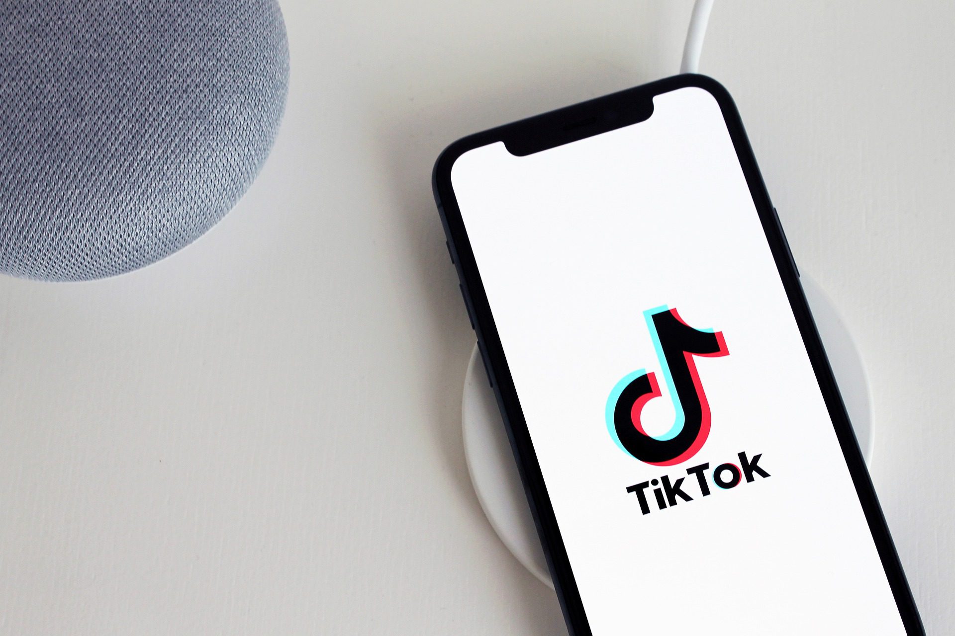 Smartfon z tapetą przedstawiającą logo TikToka