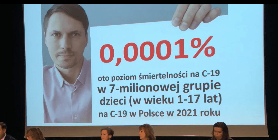 Kadr z nagrania na Facebooku, w którym widać wyświetlone na ekranie zdjęcie Grzegorza Płaczka, trzymającego w ręku kartkę z napisem: "0,0001% oto poziom śmiertelności na C-19 w 7-milionowej grupie dzieci w wieku 1-17 lat na C-19 w Polsce w 2021 roku.