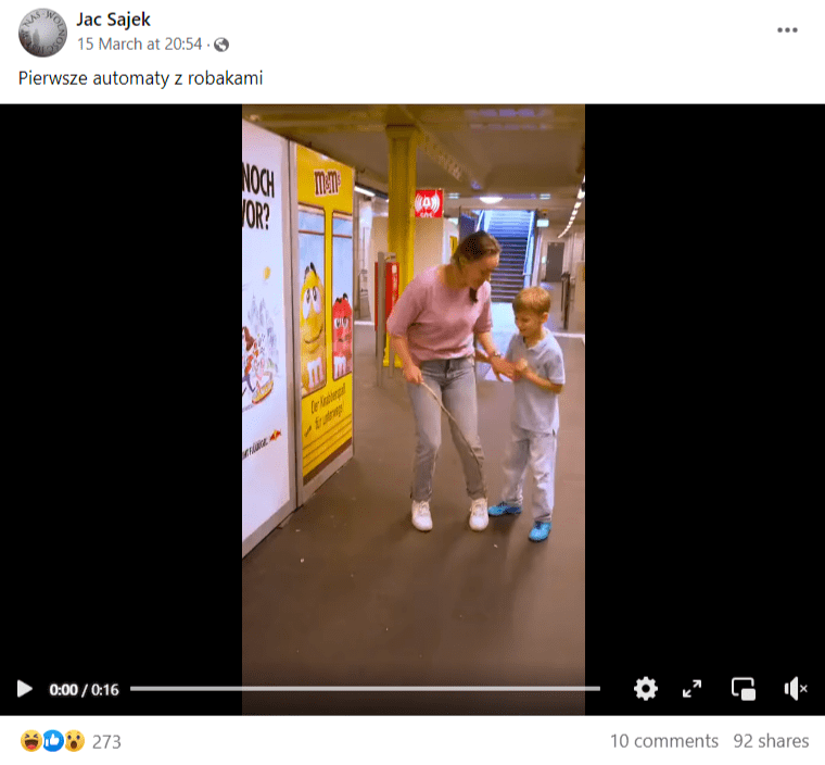 Zrzut ekranu z posta na Facebooku. Na nagraniu kobieta z dzieckiem stojąca przy automacie. Podpis sugerujący, że są to pierwsze automaty wydające owady.