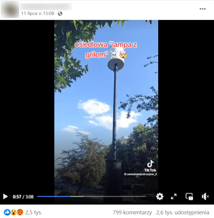 Zrzut ekranu wpisu na Facebooku, do którego dołączono nagranie z pomiarem promieniowania w miejskim otoczeniu. Na obrazie widać maszt antenowy z kloszem w formie walca w białym kolorze.