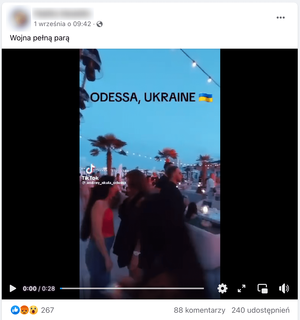 Zrzut ekranu posta na Facebooku. W kadrze dołączonego filmu widzimy ludzi stojących wieczorem na placu pod palmami. 