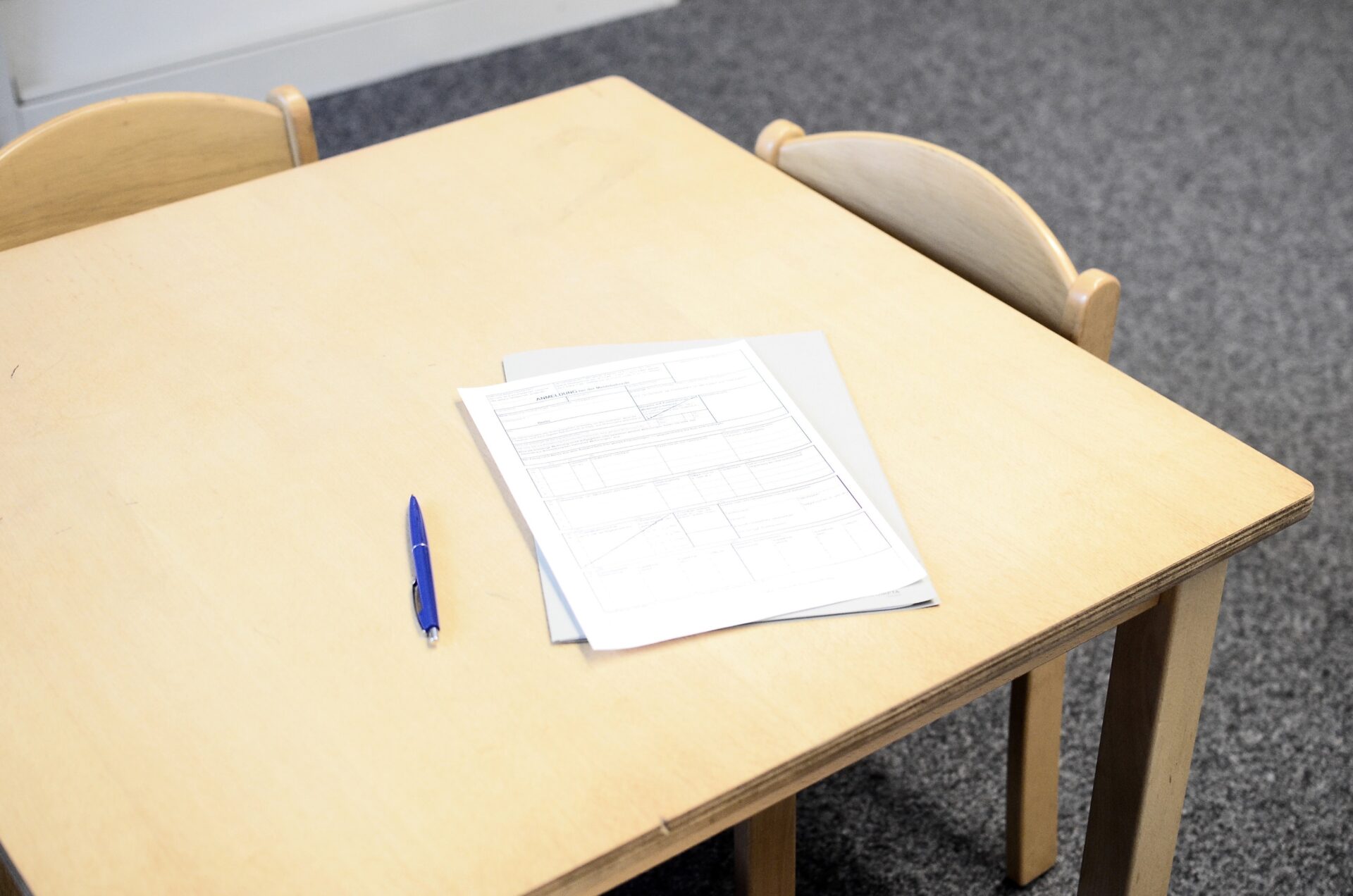 szkolny stolik z arkuszem sprawdzianu i długopisem