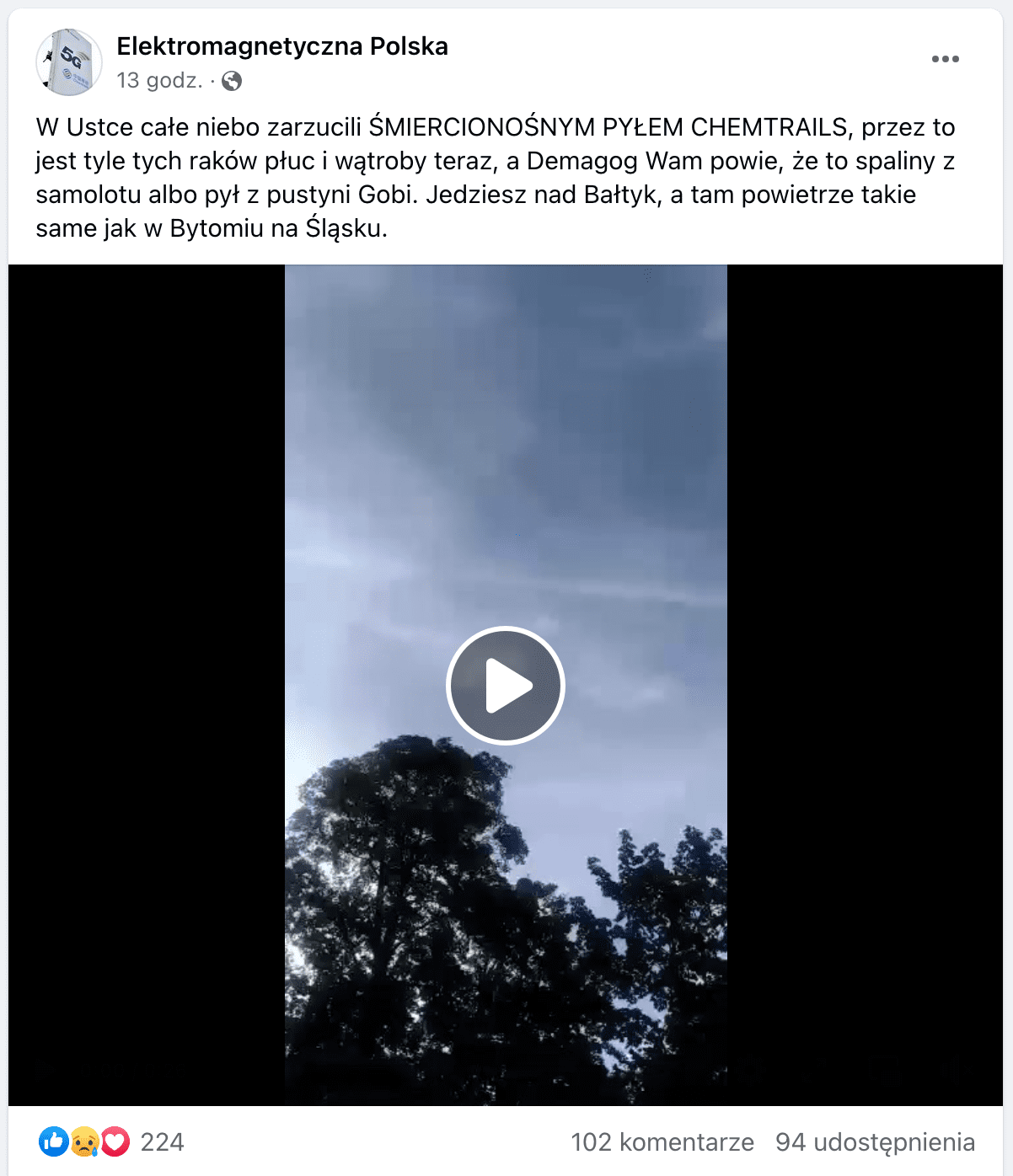 Zrzut ekranu omawianego posta na Facebooku. W kadrze filmu ujęto na drzewa na tle błękitnego nieba, które jest przecięte jasnymi smugami. 