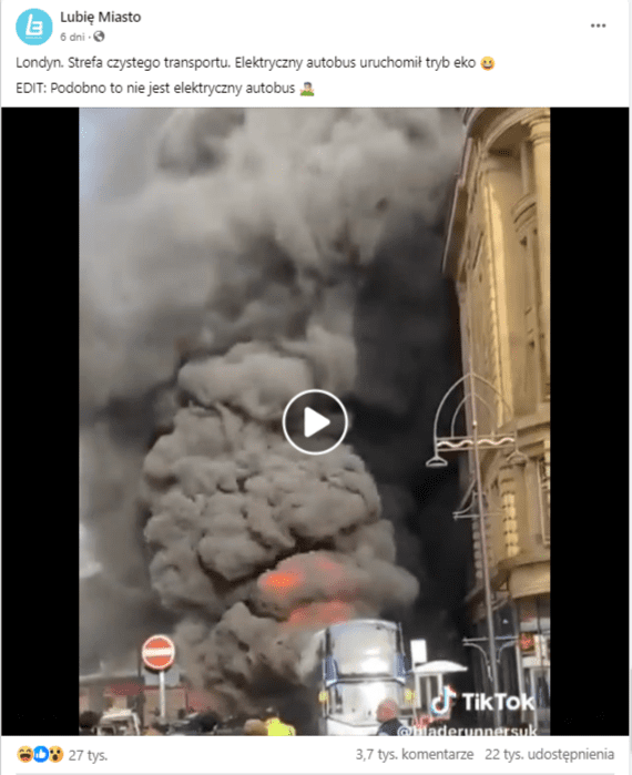 Wpis na Facebooku zawierający nagranie płonącego autobusu. Kadr przedstawia wysoki słup czarnego dymu unoszący się z pojazdu stojącego w pobliżu niskich budynków