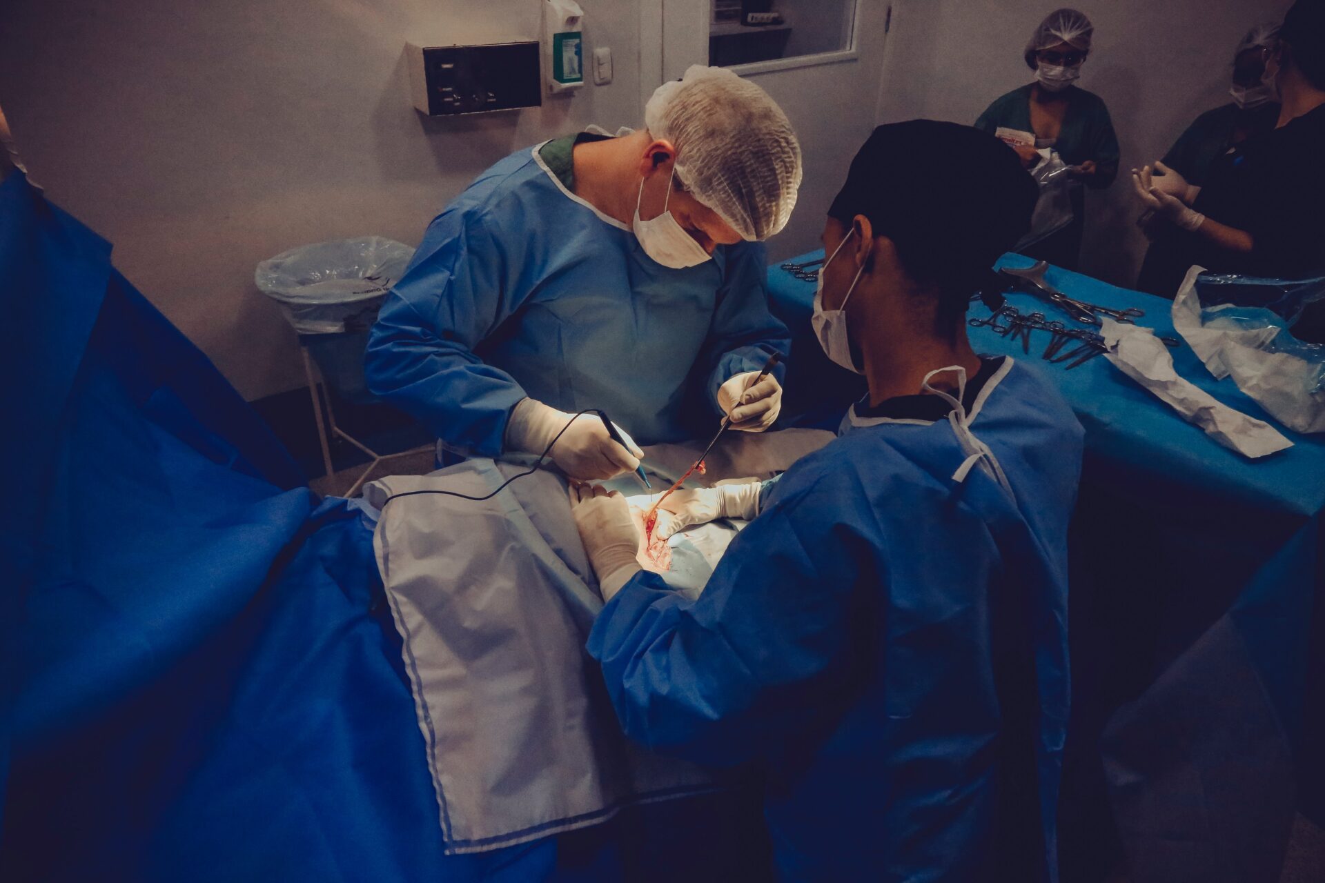 Chirurdzy stoją nad stołem operacyjnym