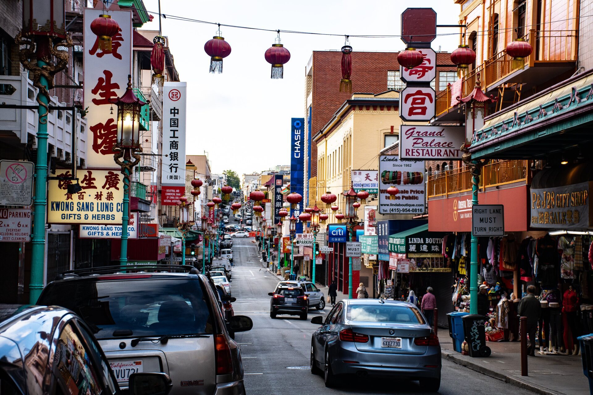 Chińska ulica, samochody, restauracje i podwieszone azjatyckie lampiony