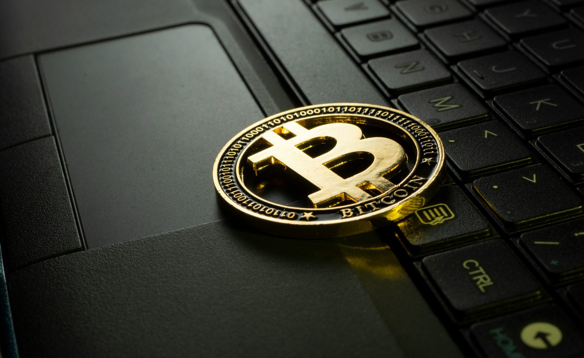 bitcoin leżący na klawiaturze laptopa