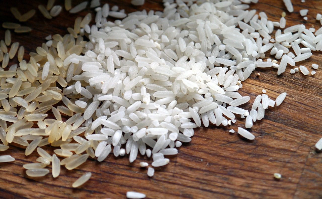Ziarenka ryżu wysypane na drewnianym stole