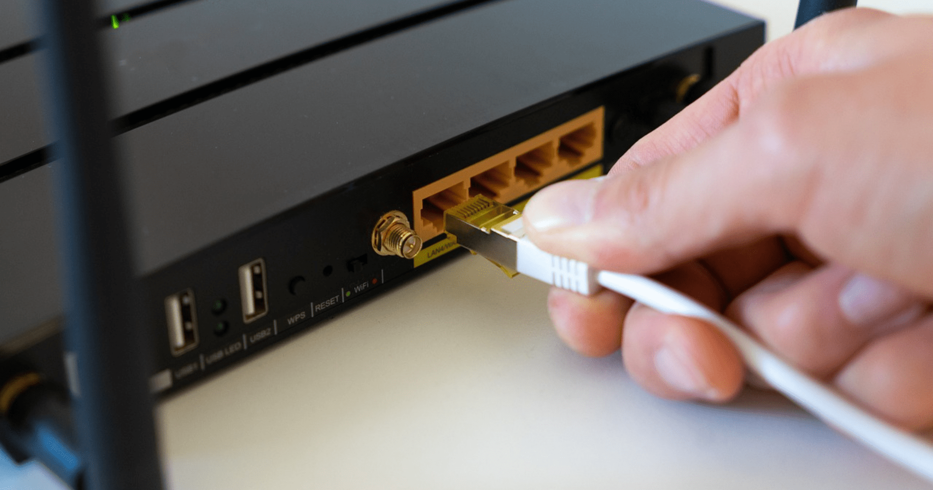 Osoba podłącza kabel WLAN do routera