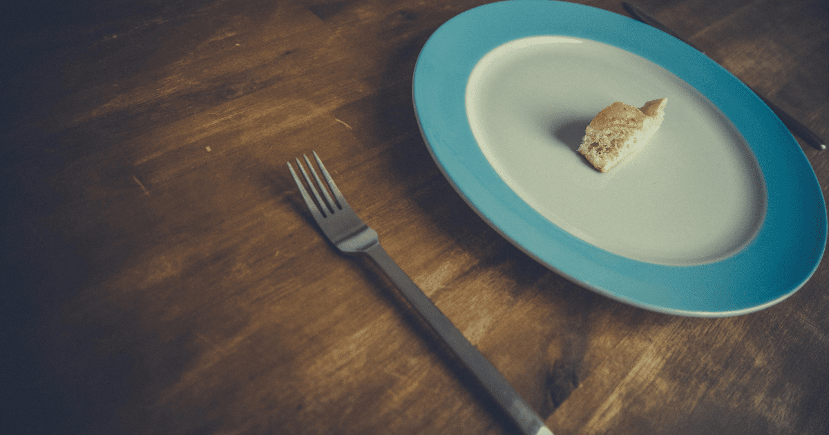 Talerz z kawałkiem chleba na stole, obok widelec