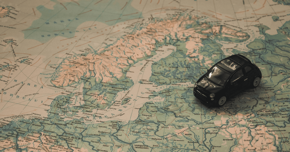 kawałek mapy Europy i czarny zabawkowy samochód