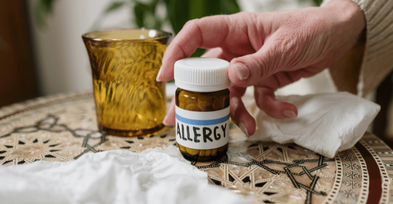 ręka sięgająca po leki na alergie