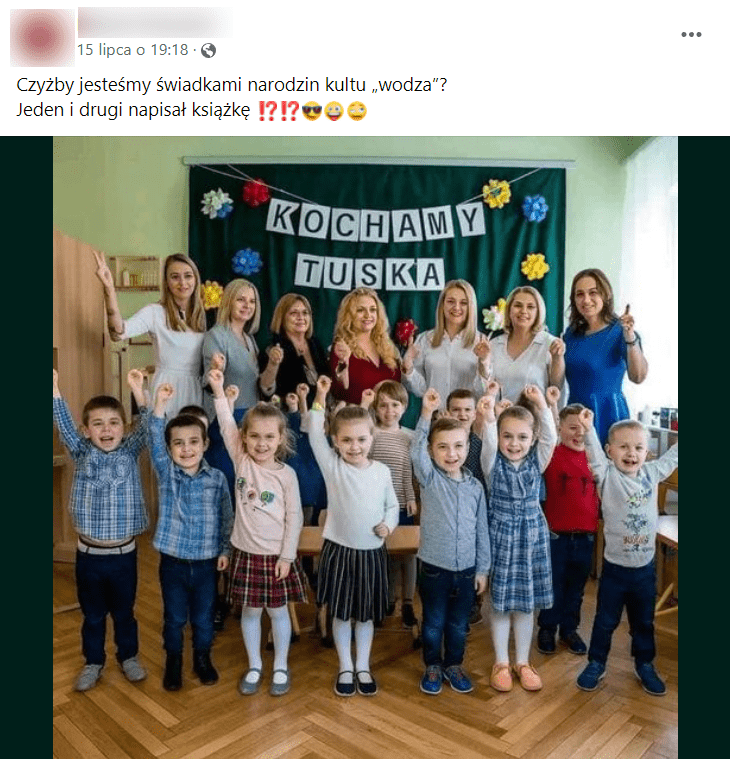 Zrzut ekranu posta na Facebooku. Widzimy gromadkę dzieci z rękami skierowanymi do góry oraz stojące za nimi nauczycielki. Na ścianie znajduje się także napis: „Kochamy Tuska”.