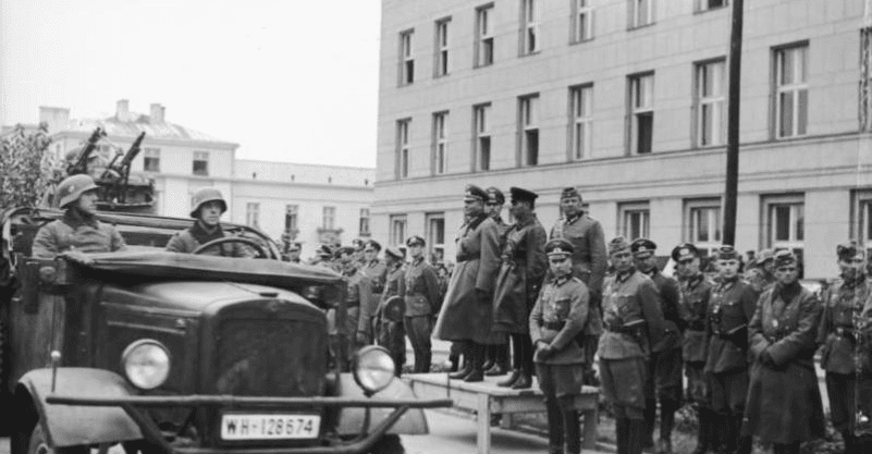 Wspólna parada Wehrmachtu i Armii Czerwonej w Brześciu, 22 września 1939. Żołnierze stojący obok siebie, po lewej stronie niemiecki samochód.