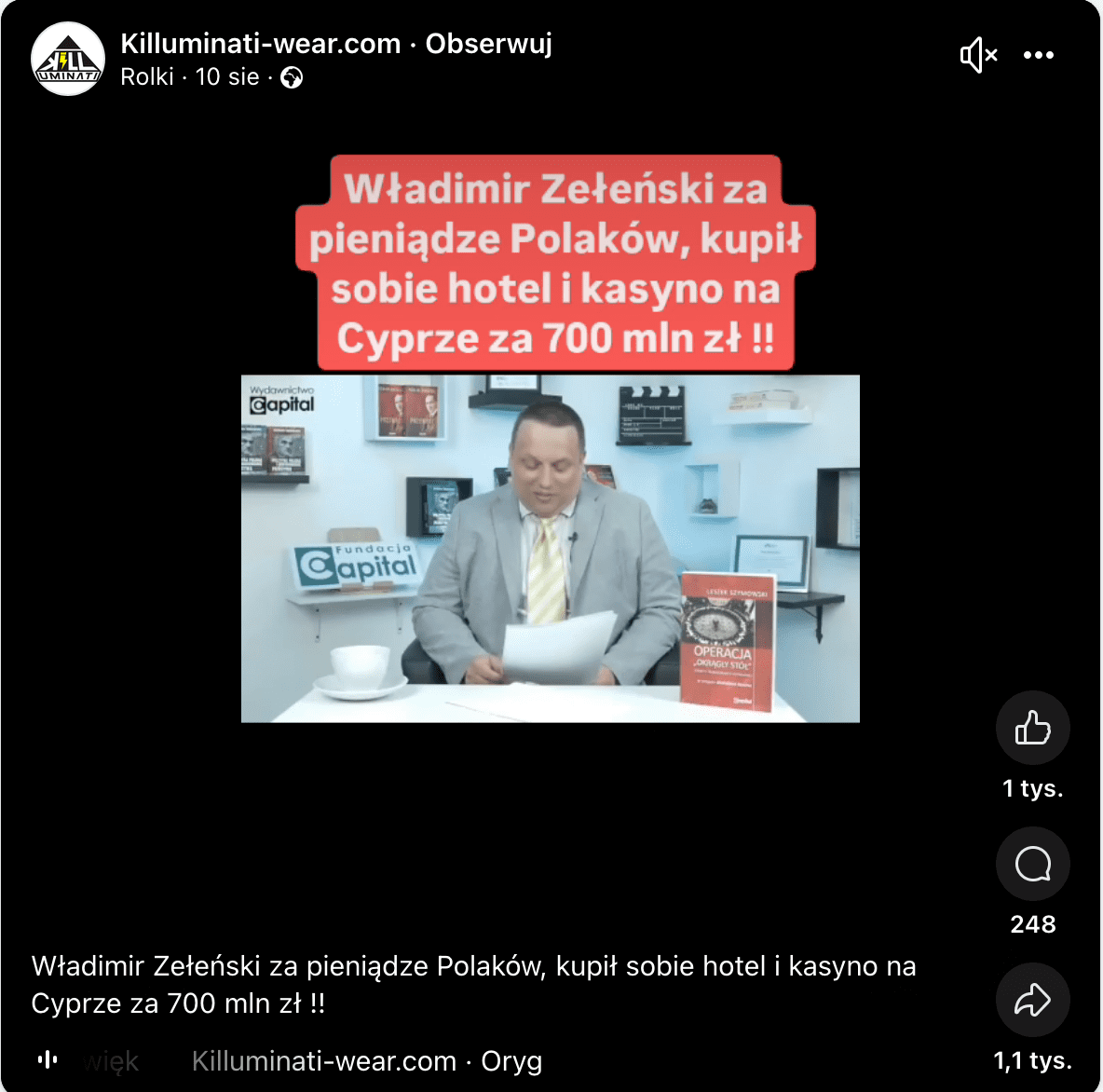 Zrzut ekranu przedstawiający rolkę opublikowaną na Facebooku przez konto Kiluminati-wear.com. W zatrzymanym kadrze widać biały napisa na czerwonym tle: [pisownia oryginalna] „Władimir Zełeński za pieniądze Polaków, kupił sobie hotel i kasyno na Cyprze za 700 mln zł !!”. Pod napisem widoczny jest kadr z nagrania z wypowiadającym się Leszkiem Szymowskim. 